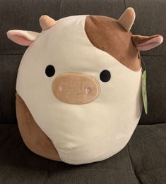 a brown and white cow pillow sitting on top of a couch