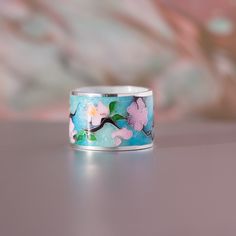 a ring with flowers painted on it sitting on a table