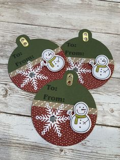 three christmas ornaments with snowmen on them