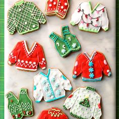 decorated cookies in the shape of sweaters and ones on a tray with green background