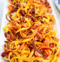 a white plate topped with sliced up carrots and onions