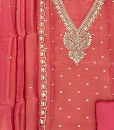 an embroidered red dress with gold and white beads on the neckline, along with matching pink pants