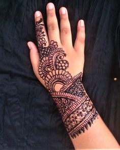 a woman's hand with henna tattoos on it