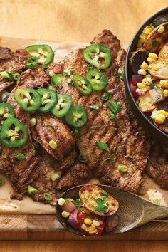 a steak with peppers and corn on the cob next to a bowl of salsa