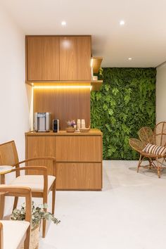 a living room filled with lots of furniture and green plants on the wall behind it