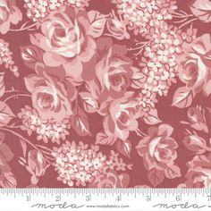 a pink and white flowered fabric with flowers on it, in front of a ruler