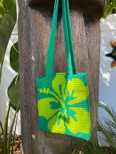 a green and yellow bag hanging from a wooden post