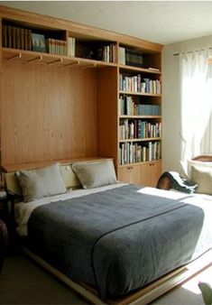 a bedroom with a bed, bookshelf and window