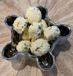 a metal bowl filled with cookies on top of a wooden table