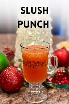 a close up of a drink in a glass on a table next to christmas decorations