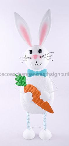 a white rabbit holding a carrot in its paws and wearing a blue bow tie, on a white background