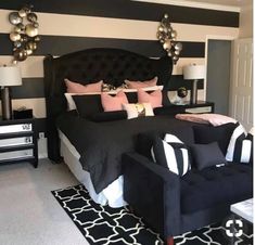 a bedroom with black and white striped walls, furniture and decor on the bed area