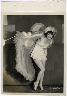 an old black and white photo of a woman dressed as a flap dancer with feathers on her head