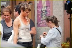 the woman is checking her cell phone while walking down the street with other people behind her