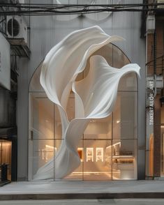 a large white sculpture in front of a building