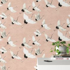 the wallpaper is pink and has white birds flying in the air, with black accents on it