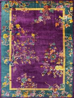 a purple and green rug with flowers on it