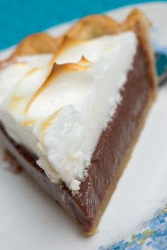 a piece of pie on a plate with a fork next to it and a blue tablecloth