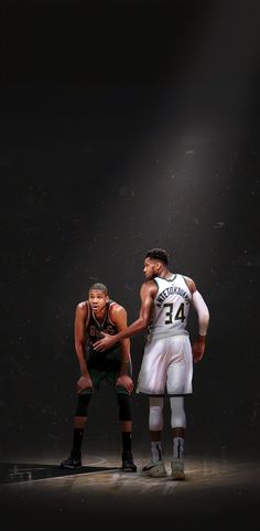 two basketball players standing next to each other in front of a dark background with spotlights