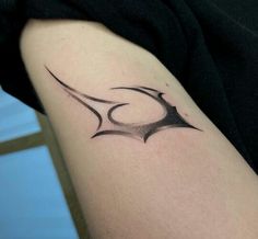 a woman's arm with a black and white tattoo design on her left arm