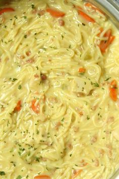 a pot filled with noodles and carrots on top of a stove