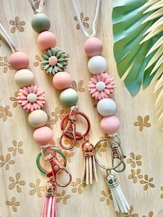 several key chains with flowers and tassels attached to them sitting on a table