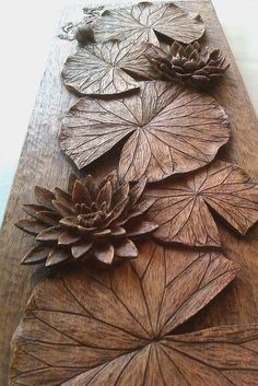 an intricately carved piece of wood with flowers on it