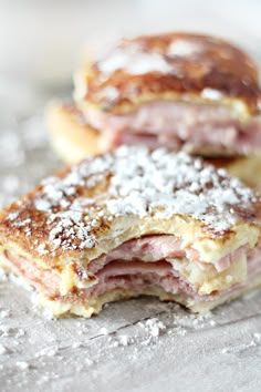 two pastries sitting on top of a table covered in powdered sugar