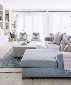 a living room filled with furniture and lots of windows