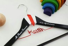 a pair of clothes hangers with personalized name on them next to some crayons