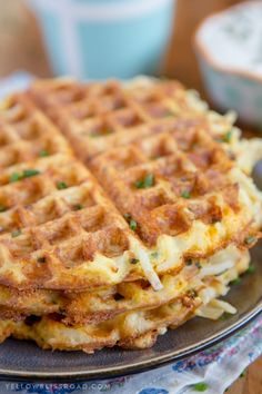 two waffles are stacked on top of each other with green onions and cheese