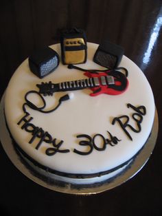 a birthday cake with an electric guitar and amp on the top that says happy 30th