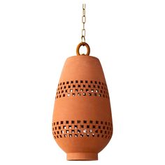 an orange vase hanging from a chain on a white background