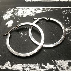 Crafted from durable 316L stainless steel, these medium-sized hand hammered hoop earrings are perfect for all occasions. Unlike sterling silver, they will NEVER TARNISH OR LOSE THEIR SHINE and are 100% waterproof. Stainless is also a great alternative for those with sensitive skin. Each polished hoop measures 1.4 inches in diameter (35mm) and closes securely with a hinge lock clasp. Bonus: these earrings come in a charming jewelry box with a soft black velvet lining - making them a fabulous gift Small Hammered Metal Hoop Earrings, Stainless Steel Hoop Jewelry With Polished Finish, Polished Stainless Steel Hoop Jewelry, Minimalist Hammered Metal Hoop Earrings, Round Stainless Steel Earrings For Anniversary, Classic Silver Stainless Steel Hoop Earrings, Everyday Stainless Steel Earrings With Polished Finish, Modern Hypoallergenic Stainless Steel Hoop Earrings, Anniversary Round Stainless Steel Earrings