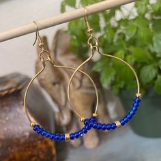 Good Tone Hoop Earrings with Royal Blue Czech Glass Seed Beads These large hoop earrings are handmade with royal blue Czech glass seed beads and gold plated beads on gold plated wire with gold plated earring wires and measure approximately 1 3/4 inches wide and 2 3/4 inches long top to bottom. * * * The last photo shows an example of the approximate size of the hoop earrings on me. These hoop earrings are perfect to wear any season and compliments Bohemian style, rustic style and vintage style o Blue Beaded Metal Hoop Earrings, Gold Round Beaded Earrings With Faceted Beads, Gold Round Faceted Beads Earrings, Gold Beaded Brass Hoop Earrings, Blue Hoop Brass Jewelry, Blue Brass Hoop Jewelry, Adjustable Gold Beaded Earrings, Gold Brass Hoop Earrings With Dangling Beads, Adjustable Gold Hoop Earrings With Faceted Beads