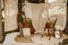 a chair sitting on top of a rug next to a wooden chair and white curtains