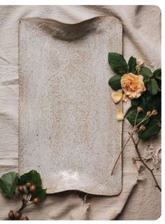 a white tray with flowers and leaves on it