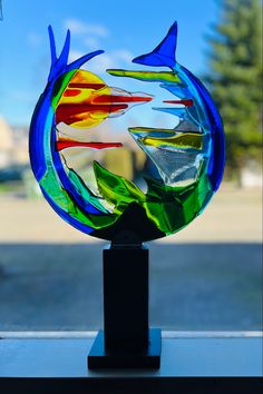 a glass fish sculpture sitting on top of a window sill