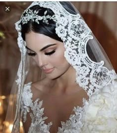 a woman wearing a wedding veil and holding a bouquet