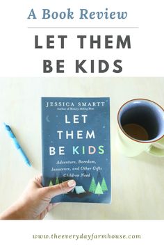 a person holding a book with the title let them be kids written on it, next to a cup of coffee