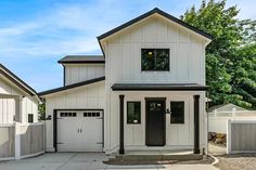 a white two story house with black trim