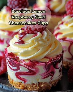 raspberry swirl cheesecake cups on a black plate with raspberries in the background