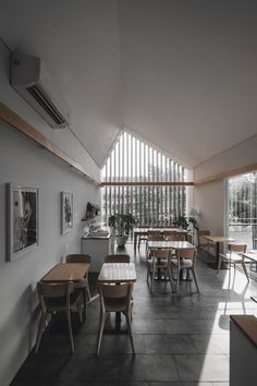 an empty room with several tables and chairs in it, all facing the same direction