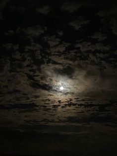 the full moon shines brightly in the dark sky above some clouds and land below