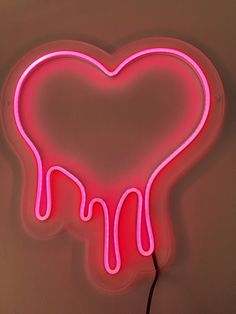 a neon pink heart shaped sign with dripping liquid