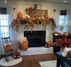 a living room decorated for fall with pumpkins and greenery on the mantel