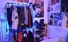 a bedroom with clothes and pictures on the wall