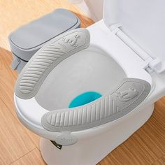 the toilet seat lid is open and there is a blue object in it's bowl