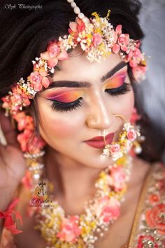 a woman with flowers in her hair and makeup