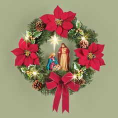 a christmas wreath with a nativity scene in the center and poinsettis around it